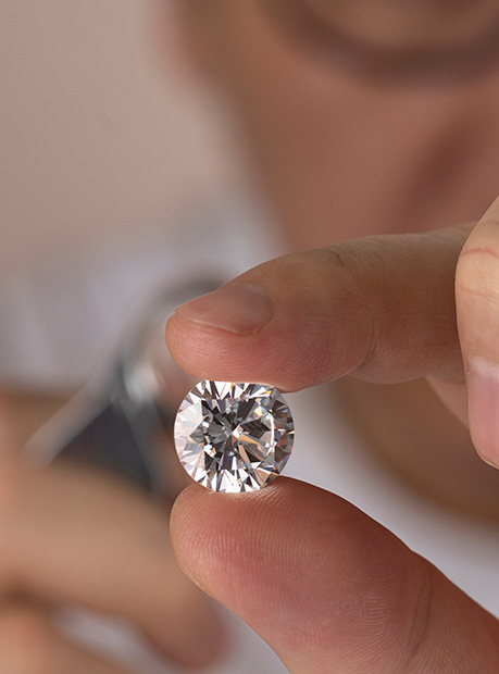 fingers holding small diamond