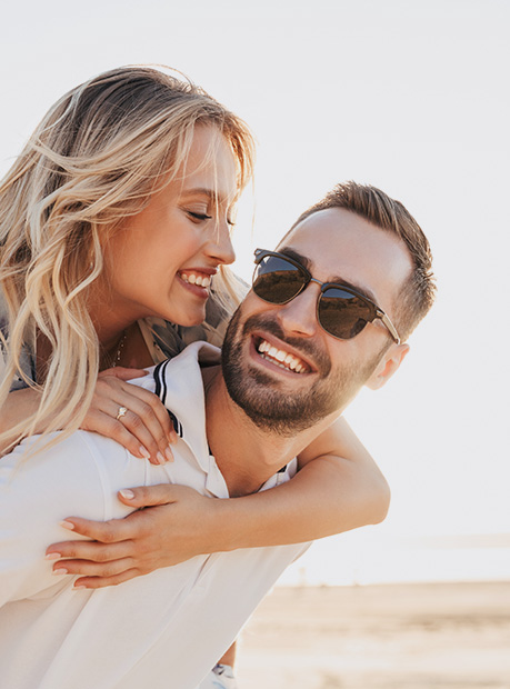 Happy woman holding onto mans back