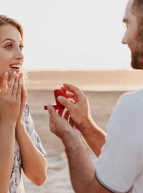 man proposing to woman on beach